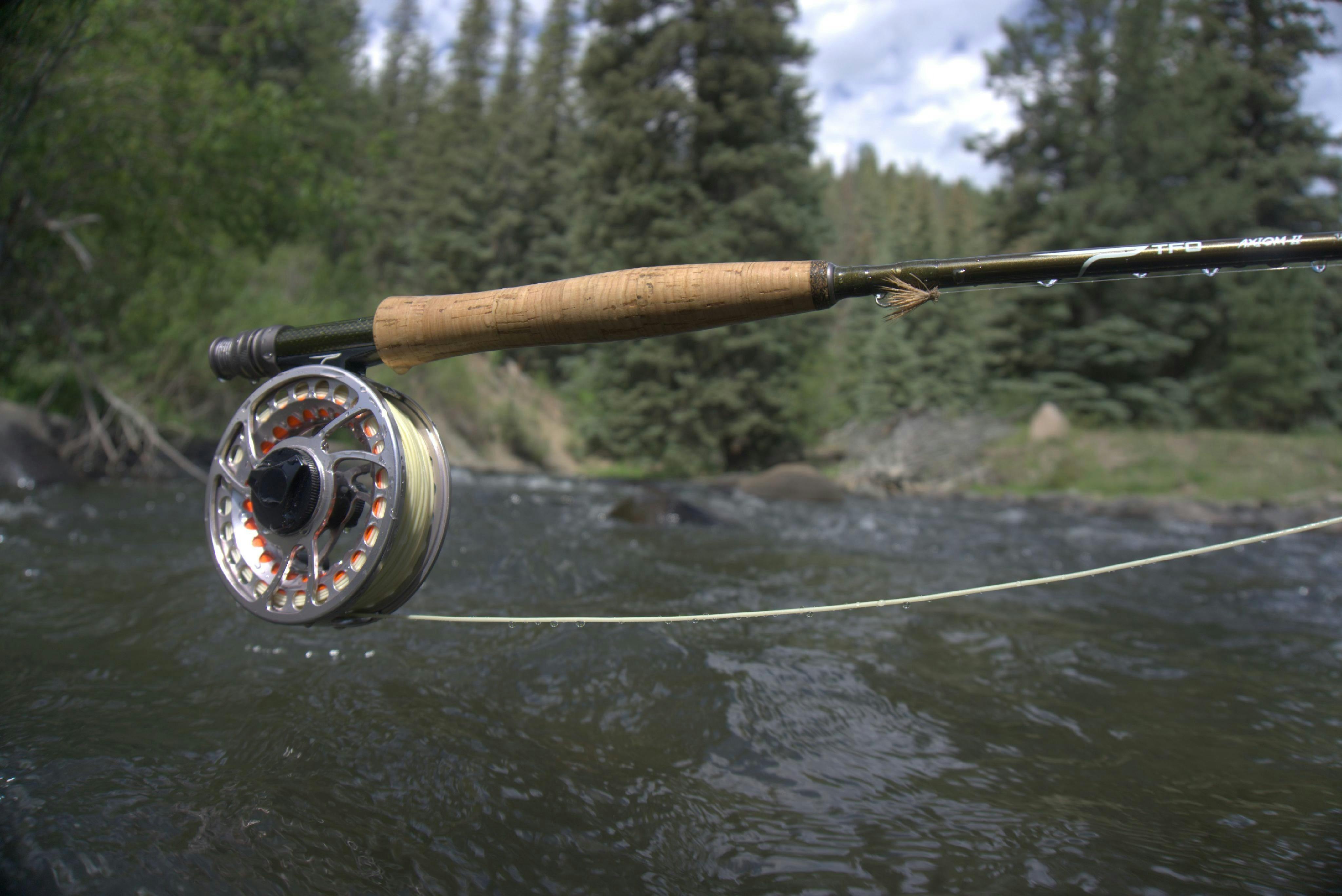The Temple Fork Outfitters BVK Sealed Drag Reel at a river.