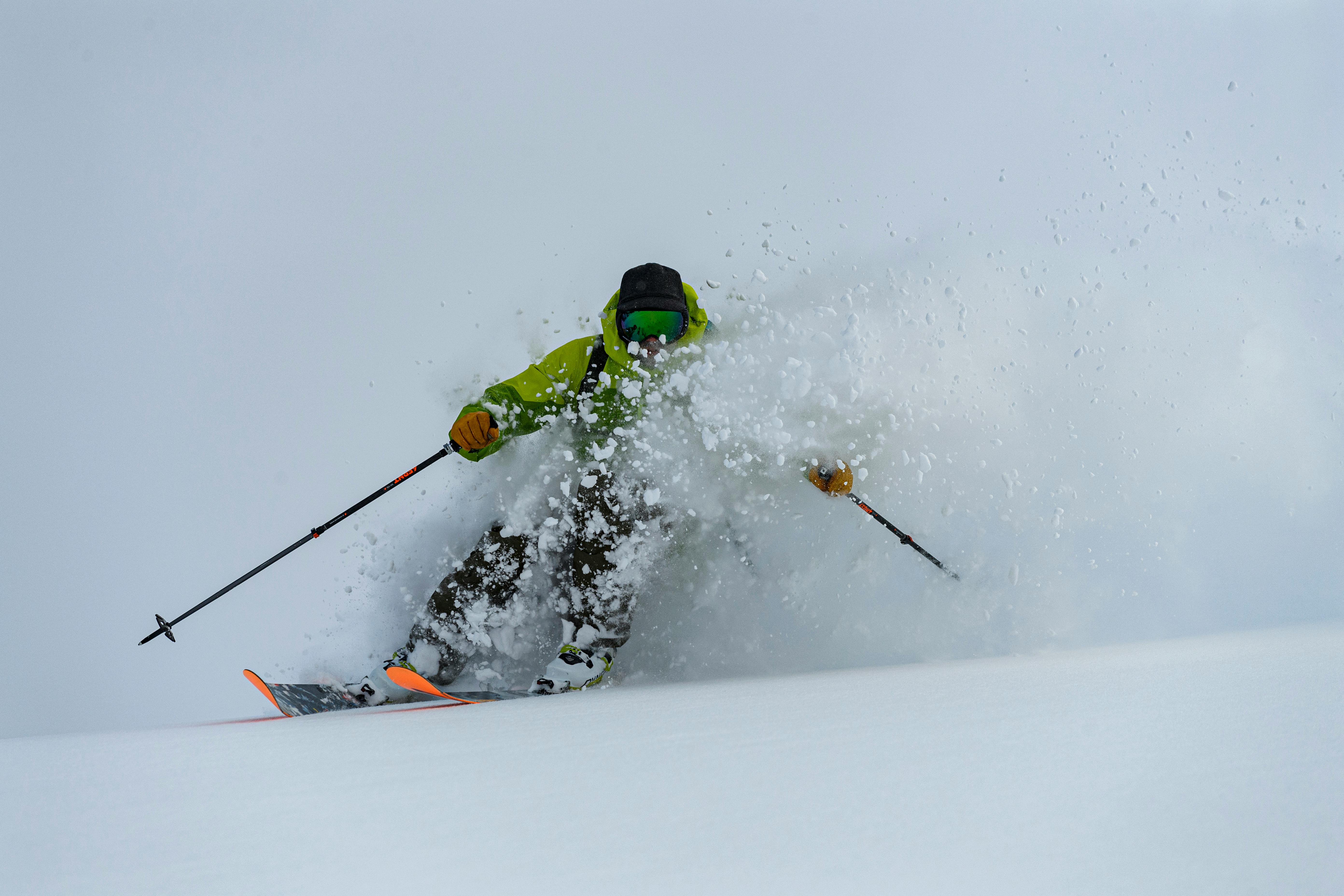A skier kicking up a wave of powder snow