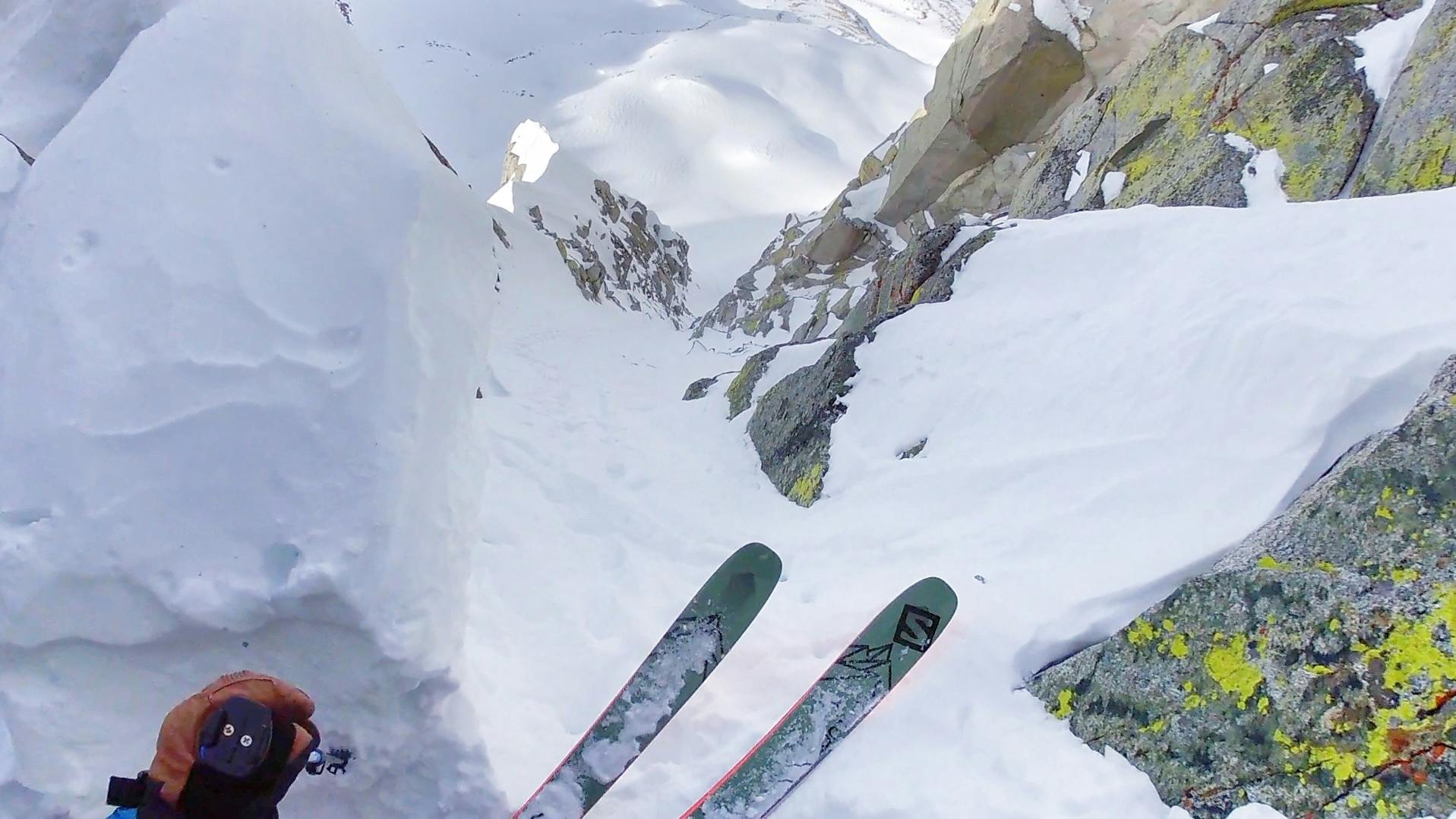 The image looks down at Josh Daiek's skis as he's perched on a steep decline.
