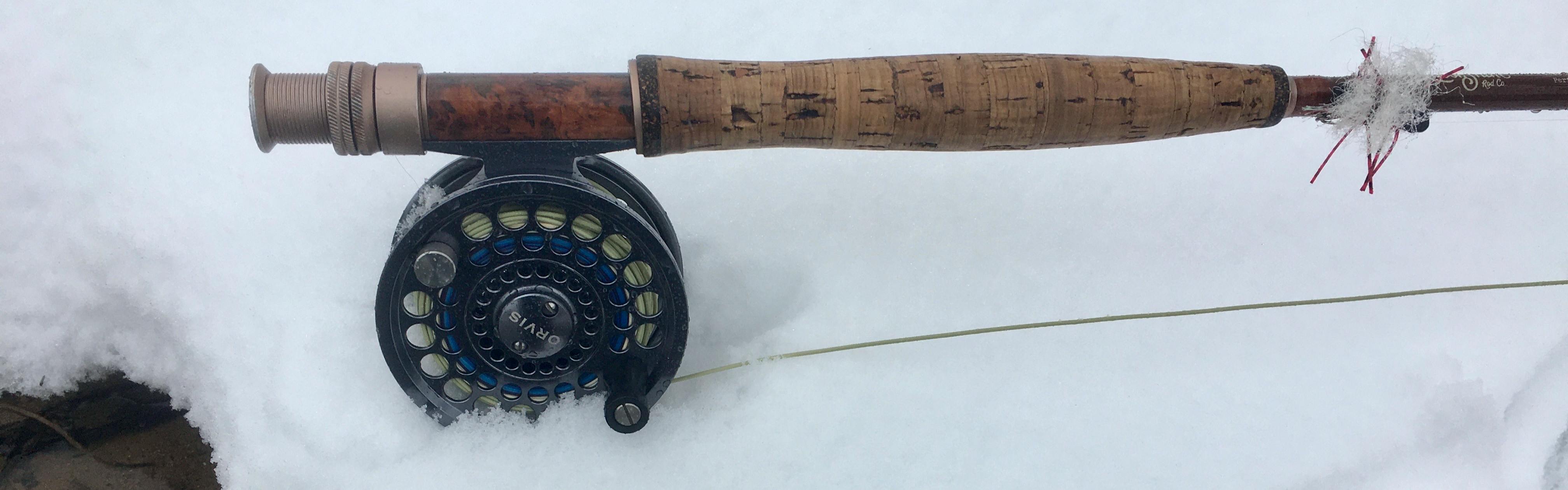 An Orvis flyfishing rod sits in the snow.