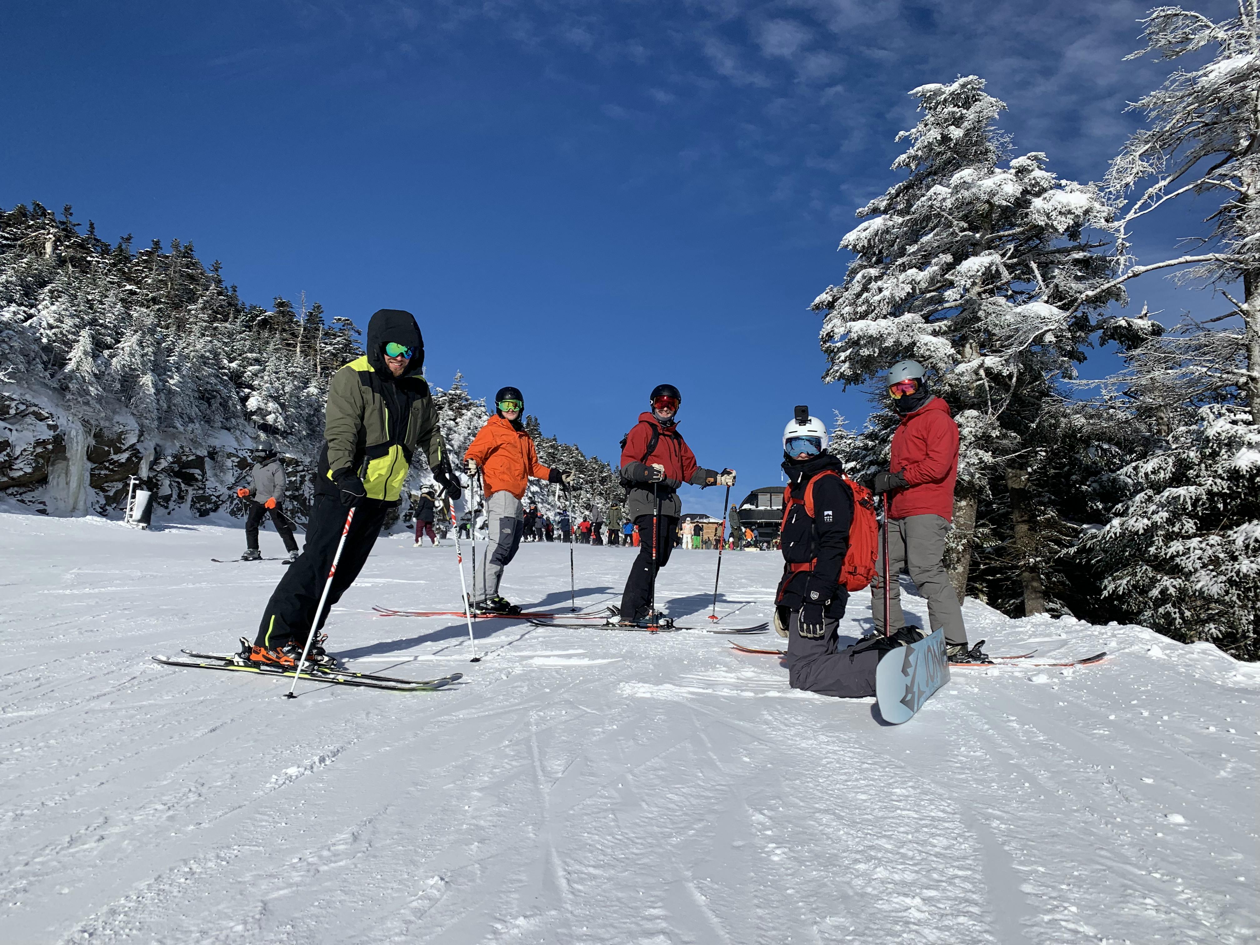 Several skier and snowboarders on a ski run. 