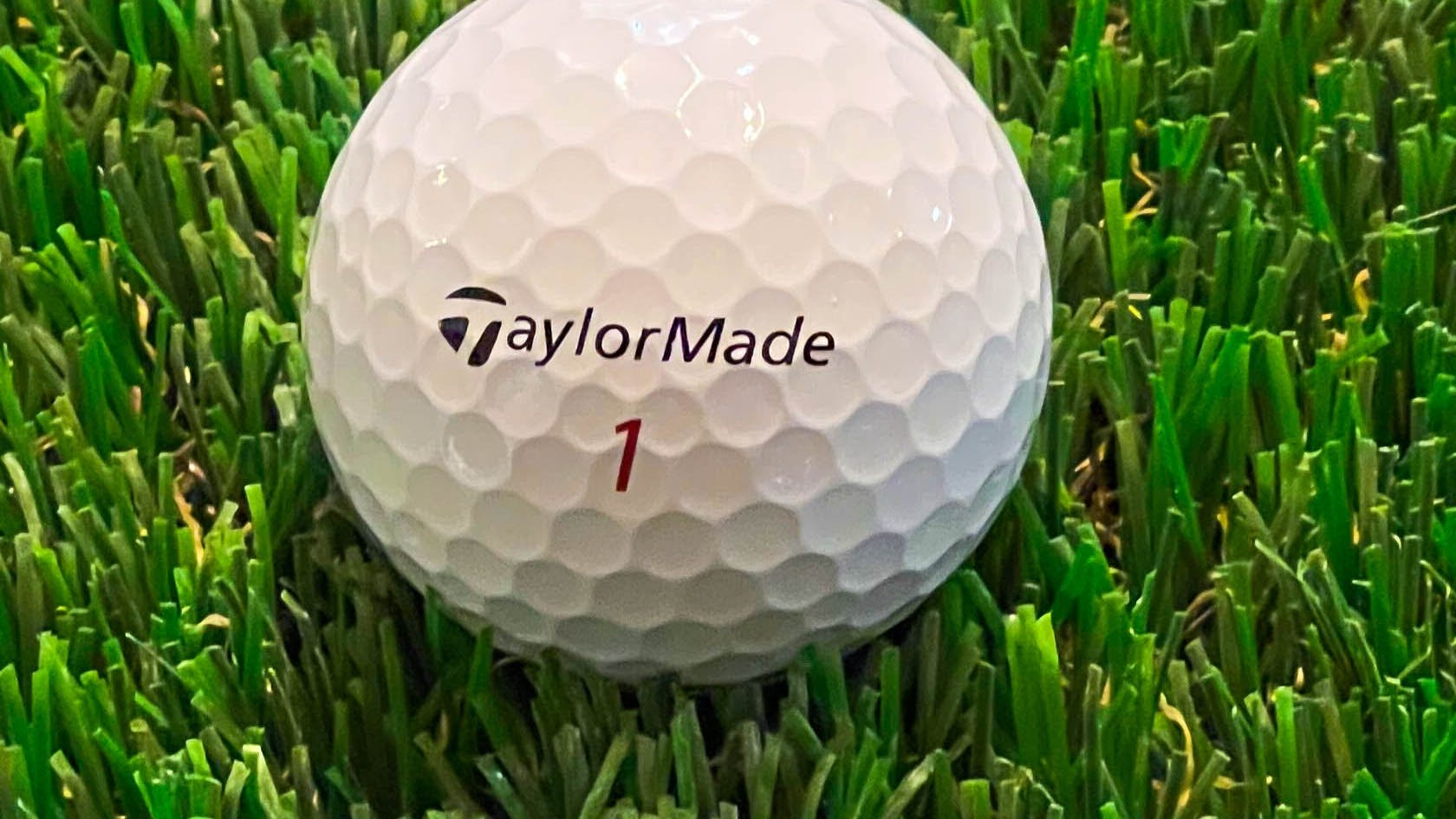 The TaylorMade TP5x ball sitting in the grass.