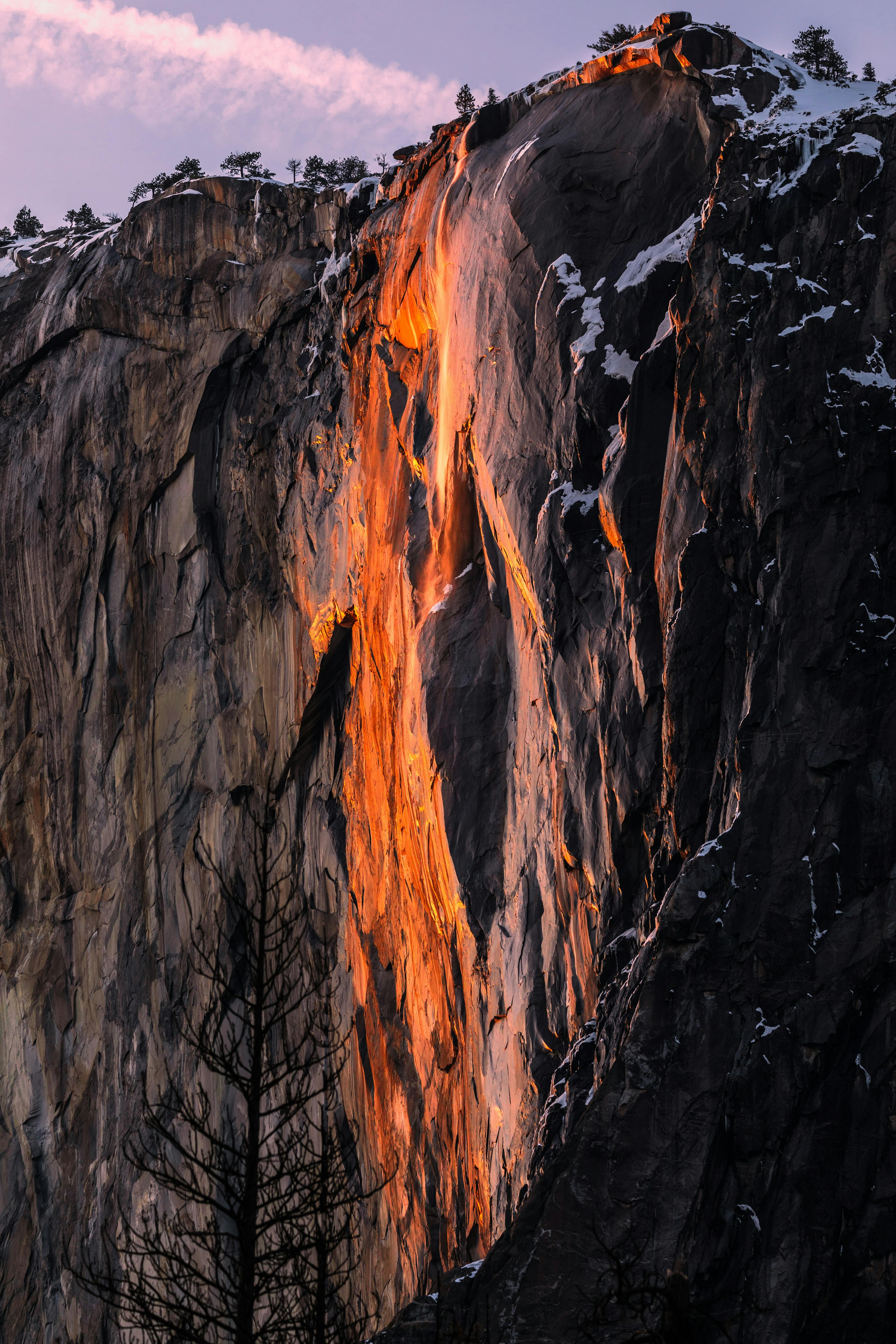 The Firefall in Yosemite with a pink and purple sky above. 