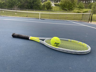 The Head Graphene 360+ Extreme Tour laying on a tennis court.