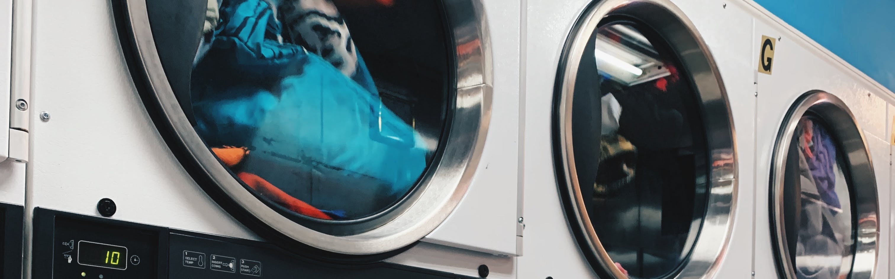 A line of washing machines at a laundromat. 