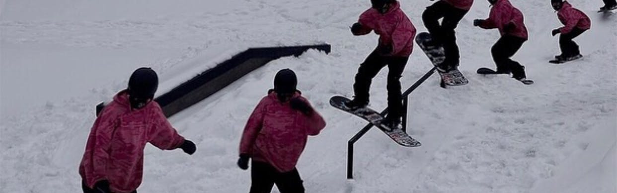 A snowboarder rides a rail.