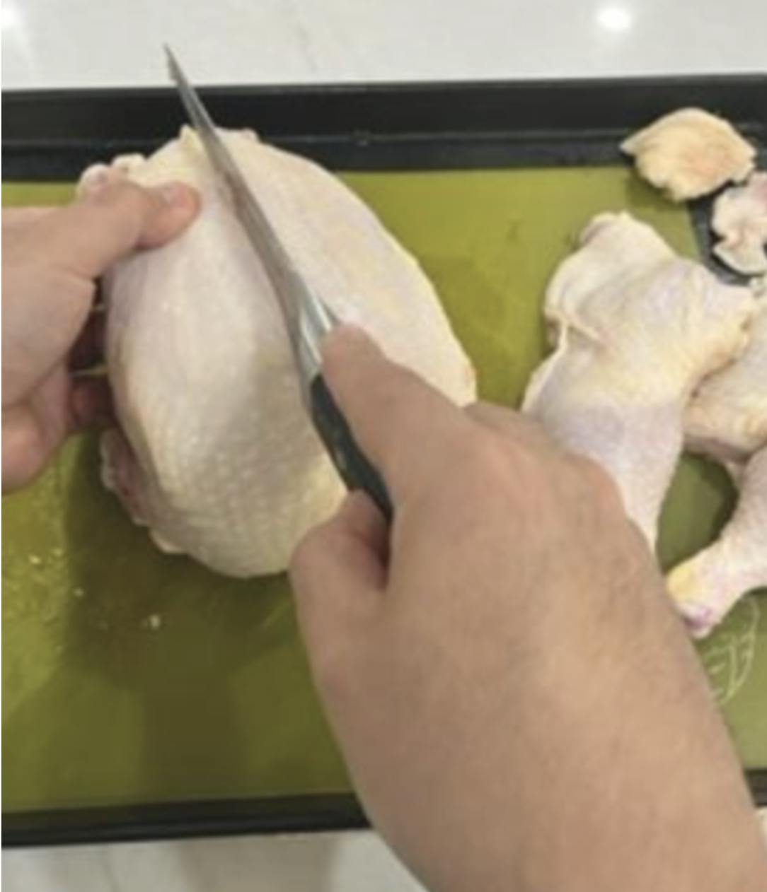 Cutting the breast off a chicken. 
