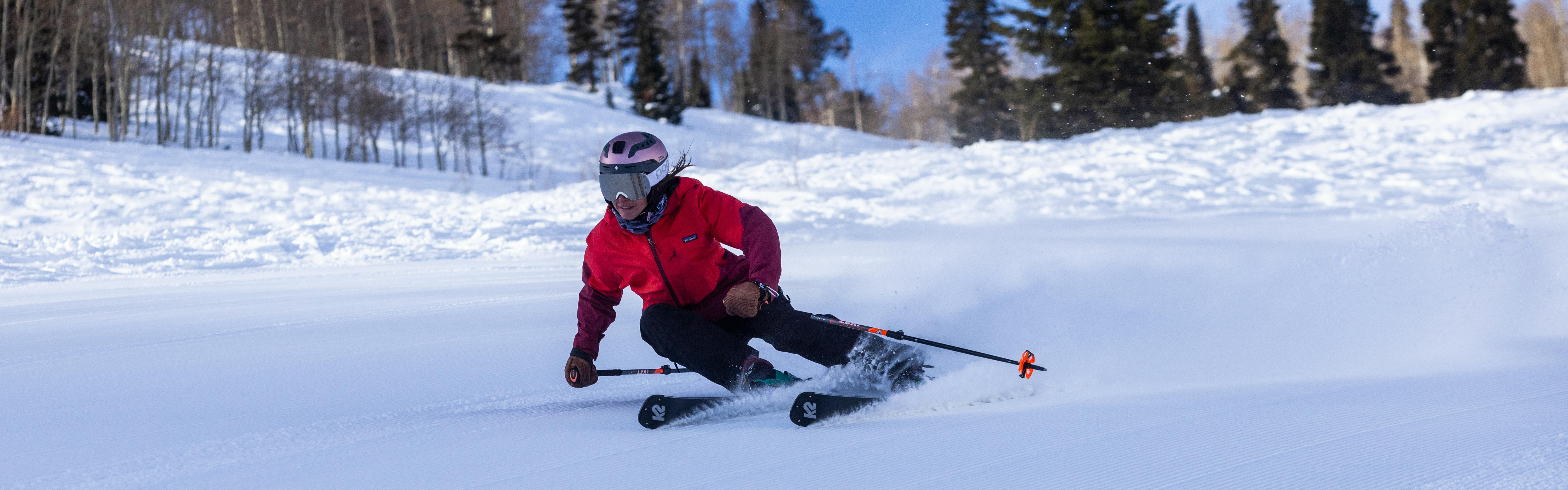A woman skis downhill on K2 skis.