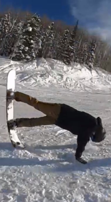 A snowboarder doing a trick while wearing the Burton AK GORE-TEX Clutch Mitt.
