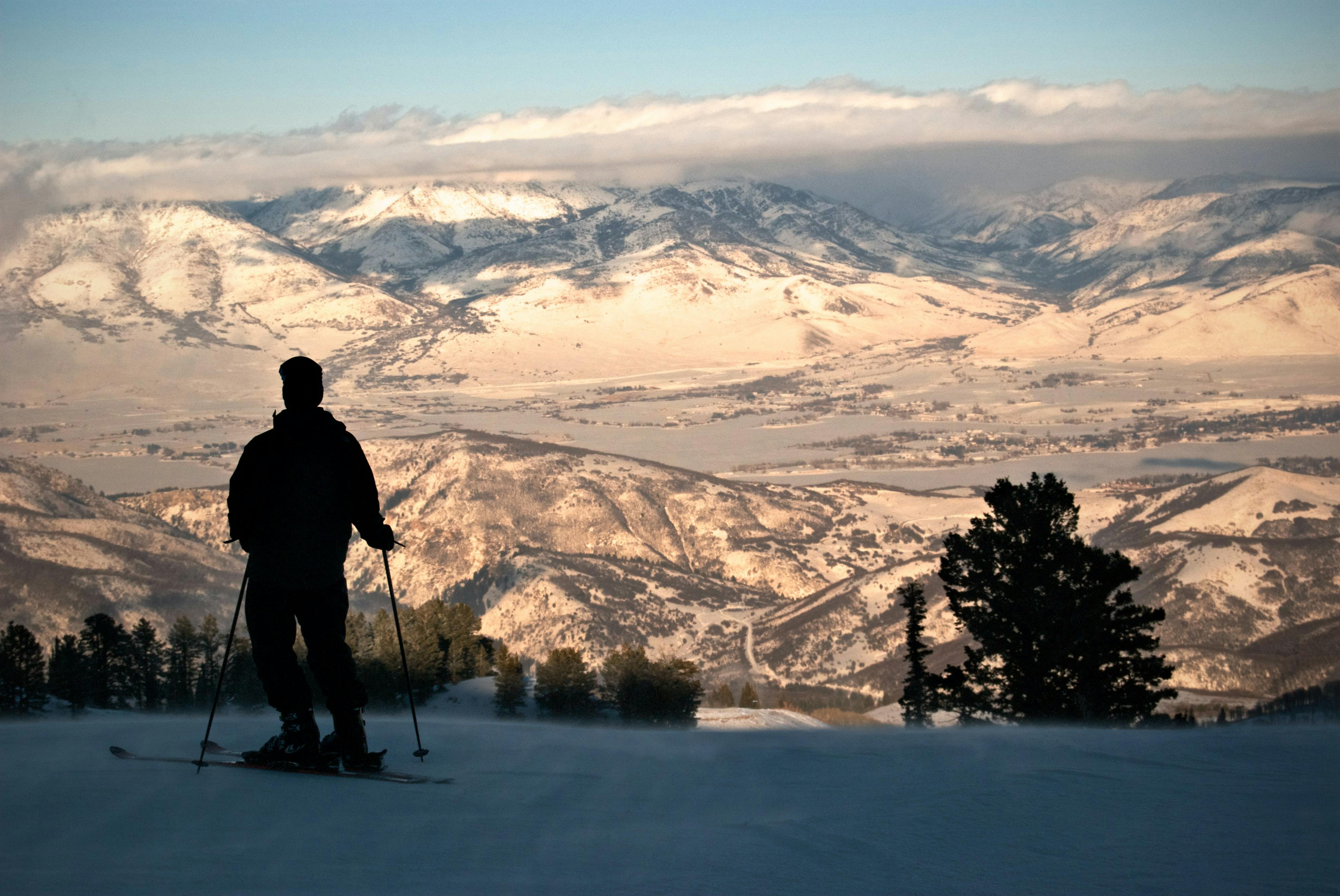 A skier standing at the top of a snowy run. 