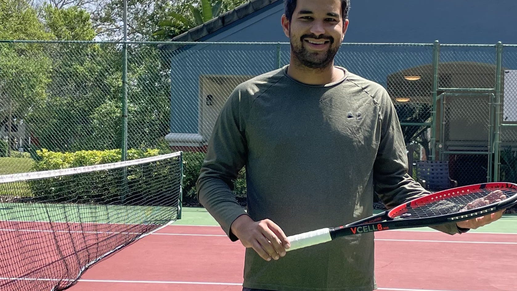 A tennis player holding the  Volkl V-Cell 8 300g Racquet · Unstrung. 