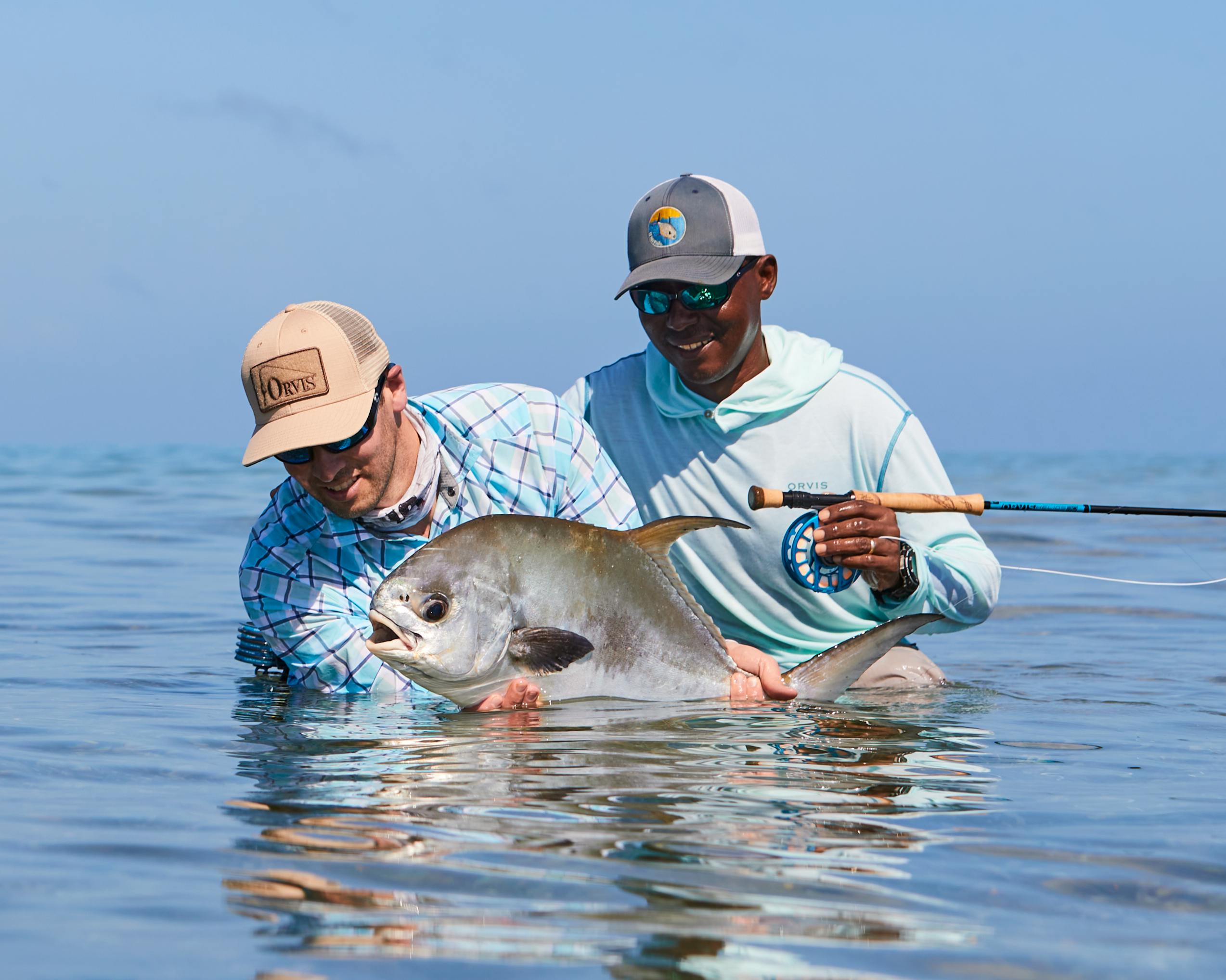 Orvis CEO Simon Perkins releases a permit in Punta Dorda, Belize while fishing with legendary guide Scully Garbutt.