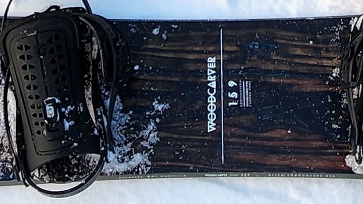 The Nitro Woodcarver Snowboard · 2022 laying in the snow. 