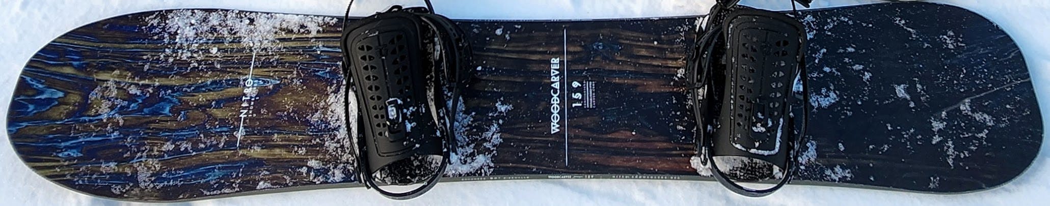 The Nitro Woodcarver Snowboard · 2022 laying in the snow. 