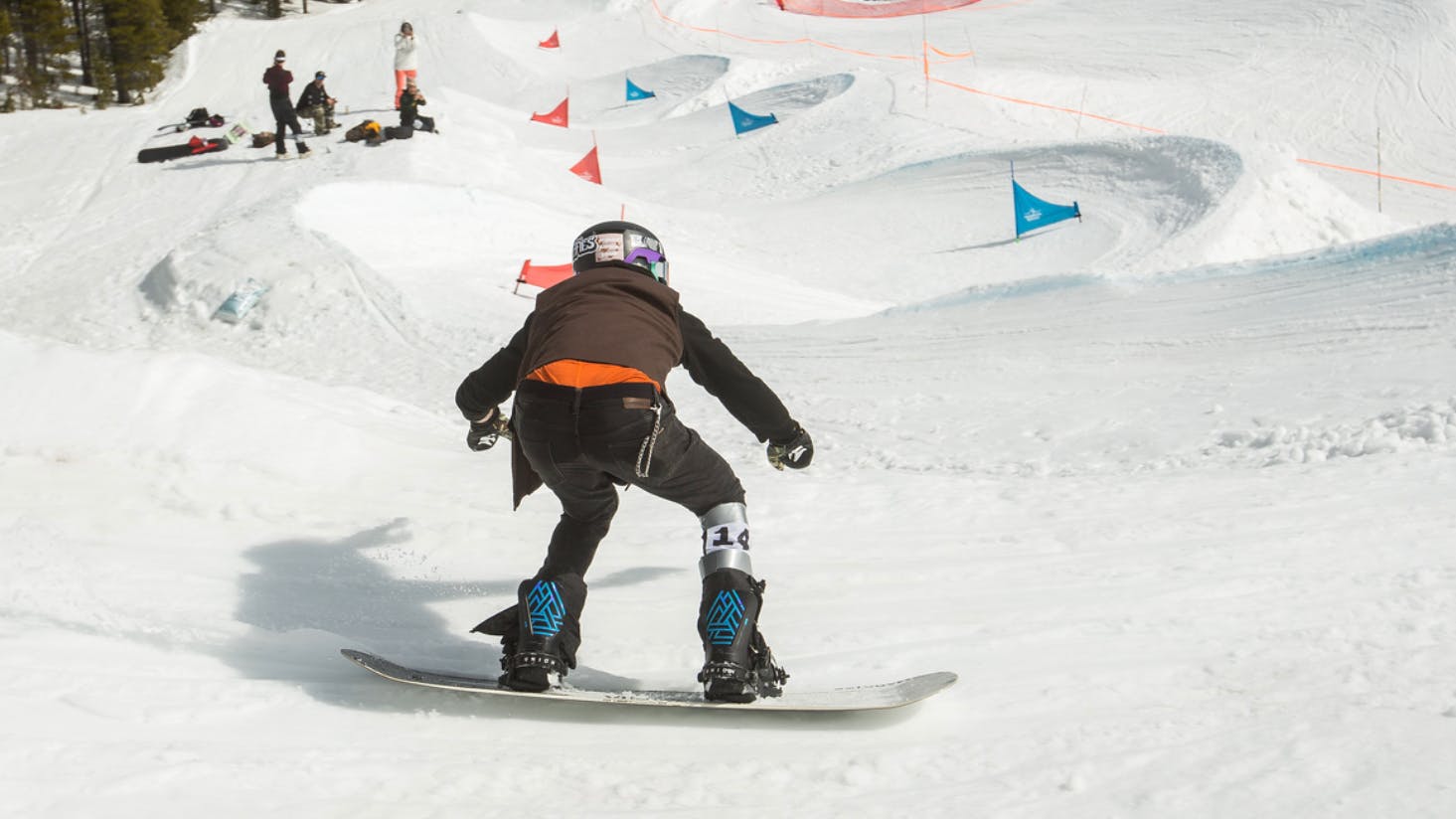 A snowboarder riding a snowboard with the Atlas Pro snowboard bindings.