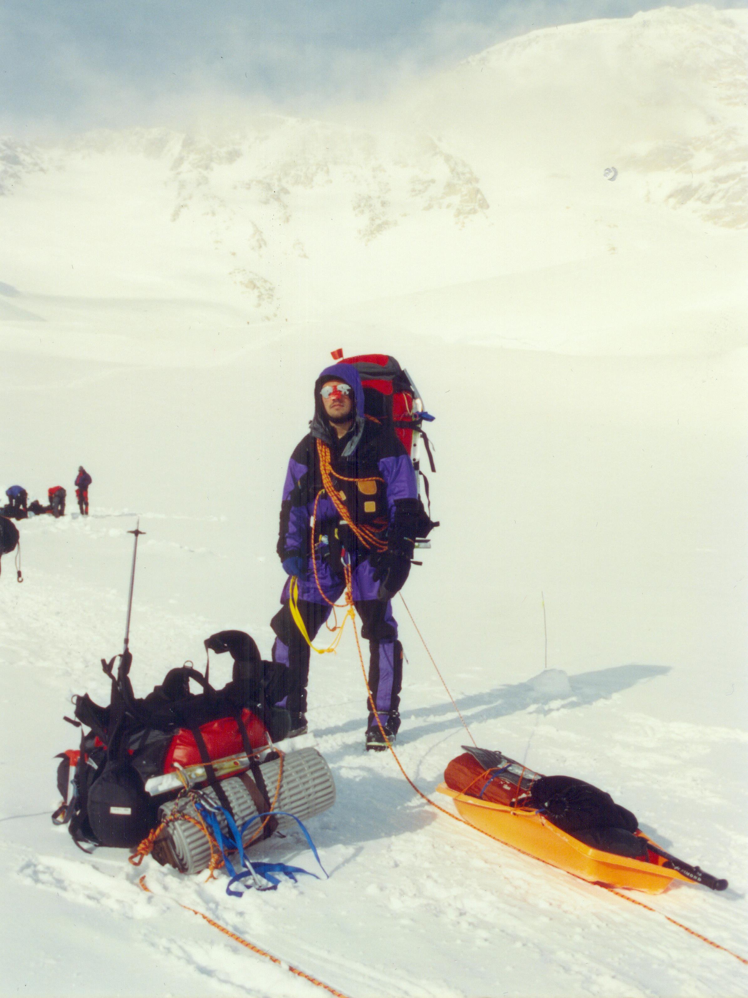 Nemo Equipment Founder Cam Bresinger with a backpack and a sled of gear in a desolate winter landscape