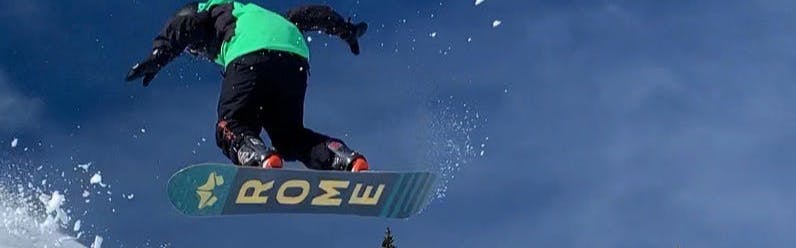 A snowboarder jumping on the Rome Stale Crewzer Snowboard · 2021.