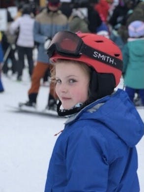 A girl in ski gear wearing the Smith MIPS helmet. 