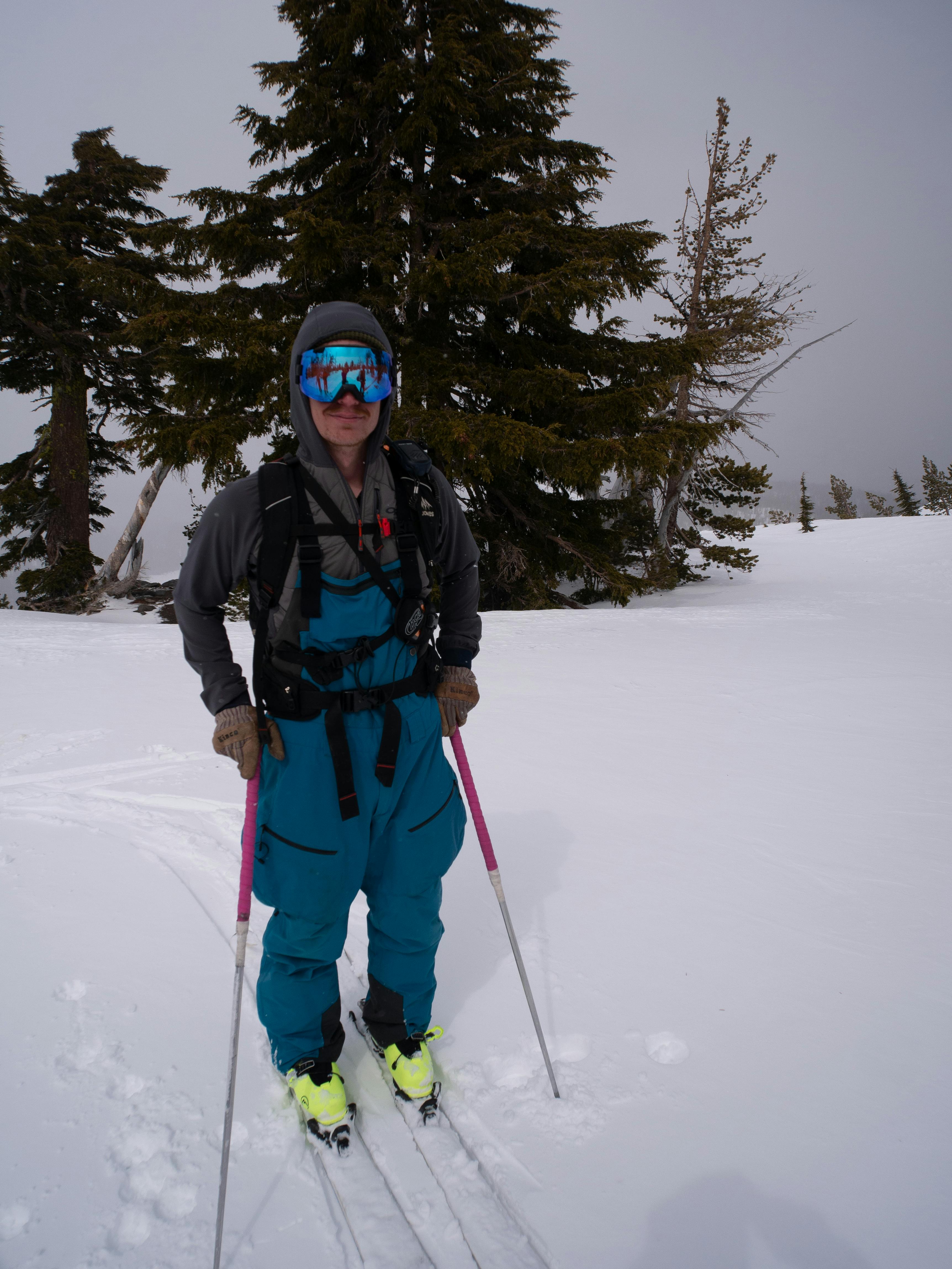 A skier standing on his skis and wearing the Mountain Hardwear Men's Firefall™ Bib Pants.