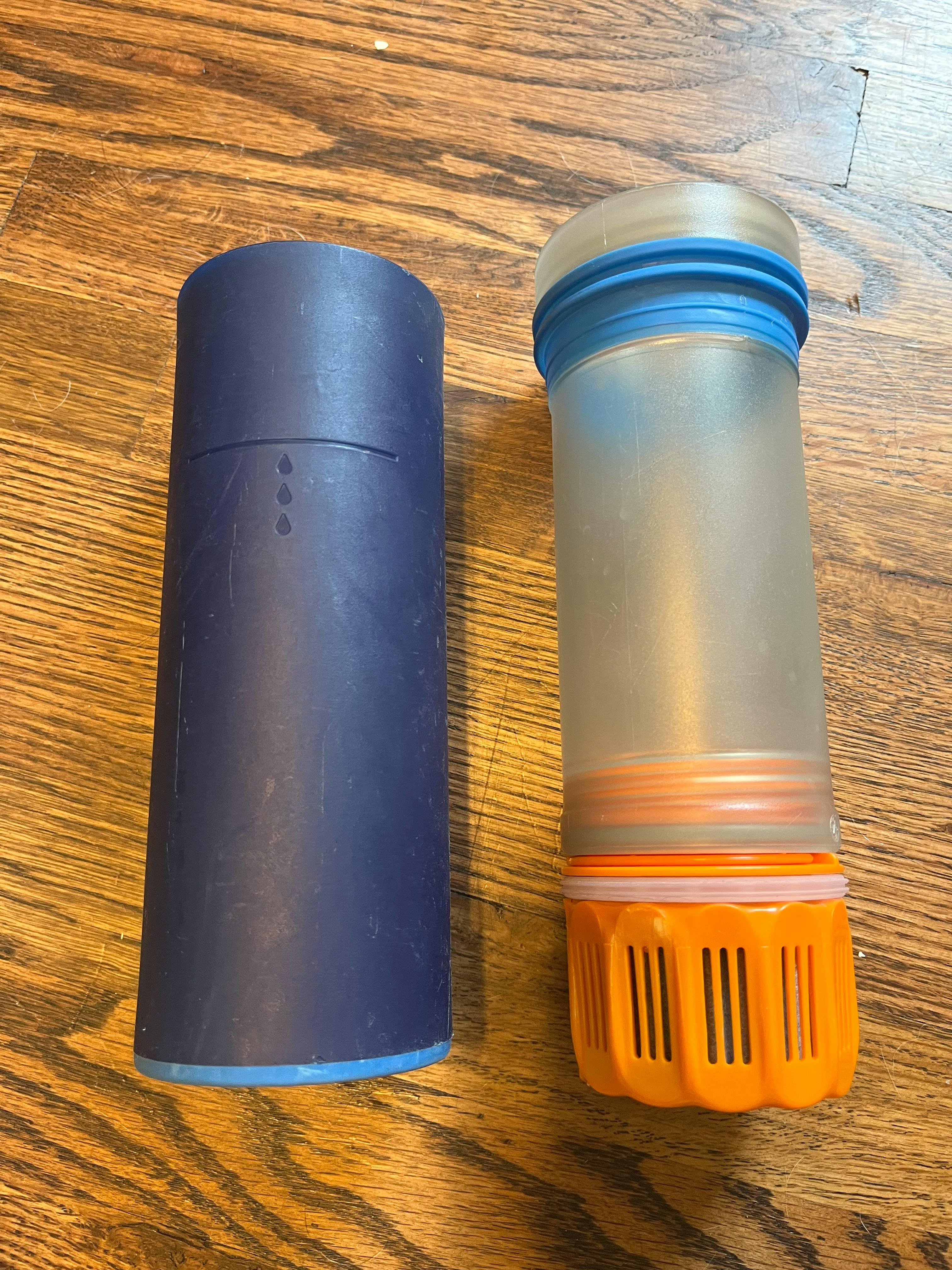 Two parts of the Grayl Purification Bottle laying next to each other. 