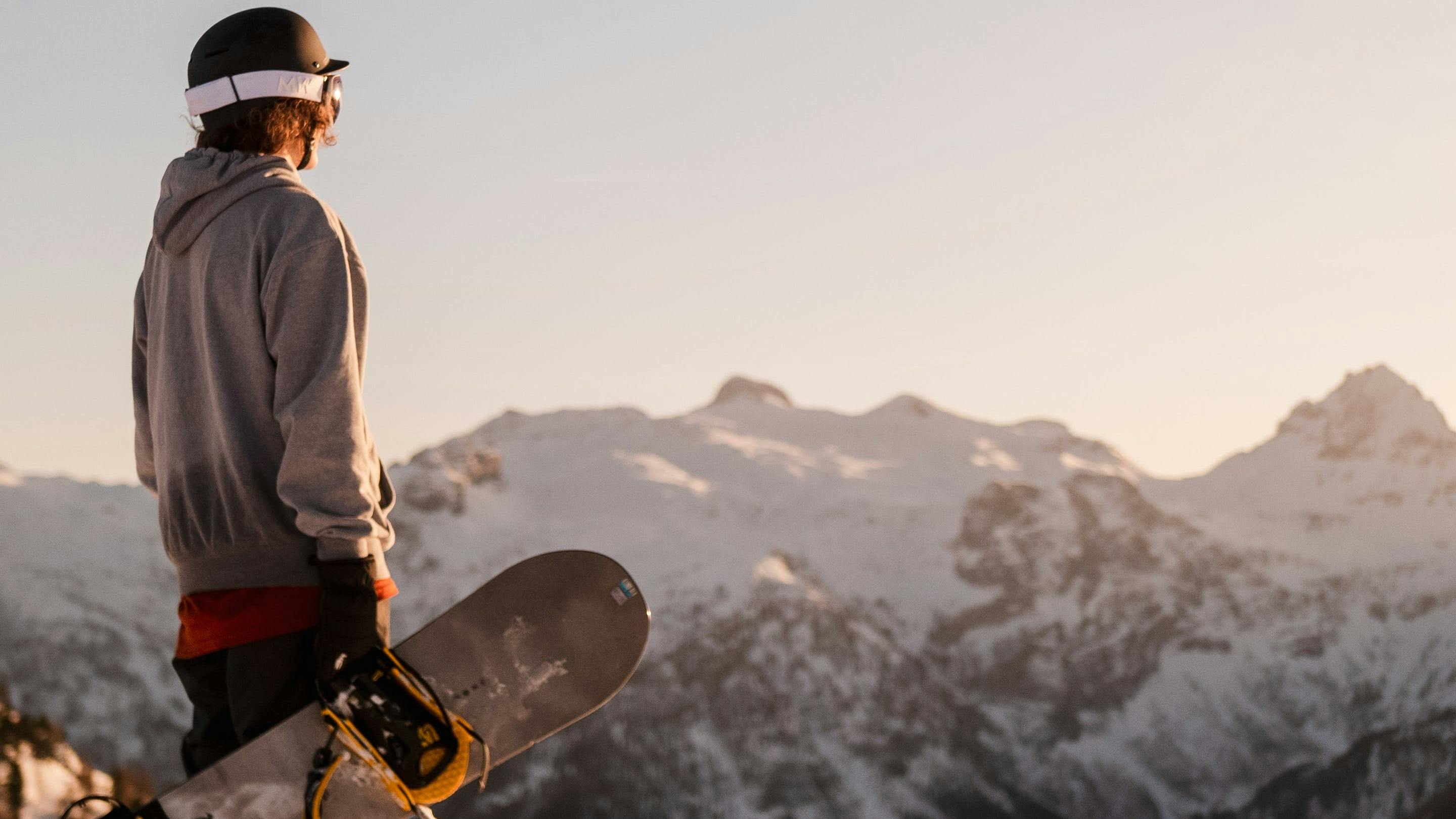 Snowboarder looking over a mountain range.