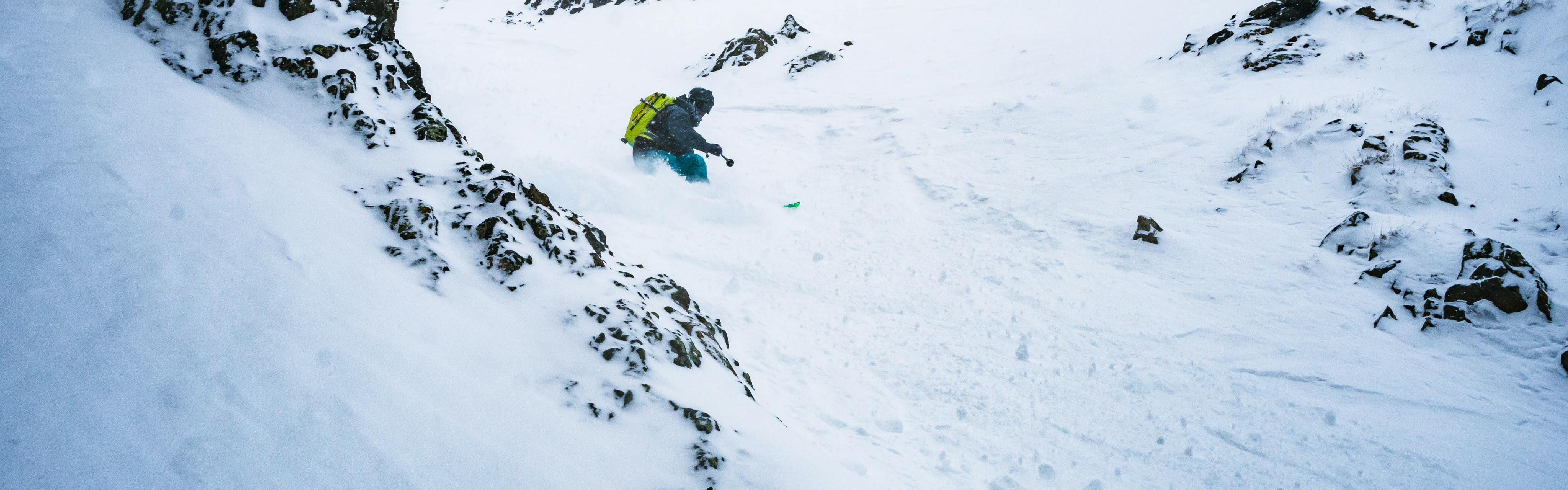 A skier turning down a chute.