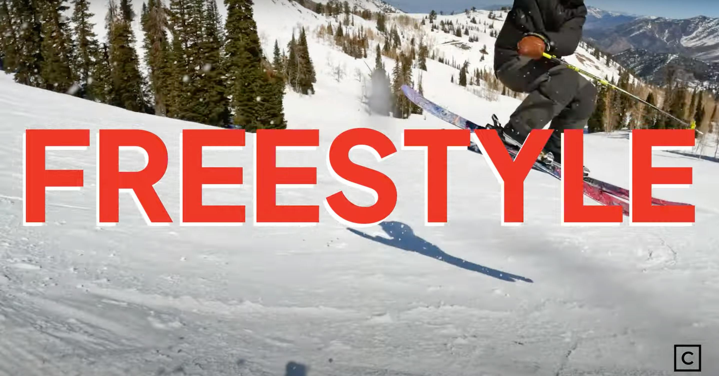 A skier doing a jump with the word "Freestyle" overlayed. 