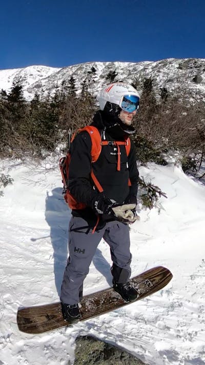 A snowboarder in the Helly Hansen Men's Ridge Infinity Shell Bib Pants.