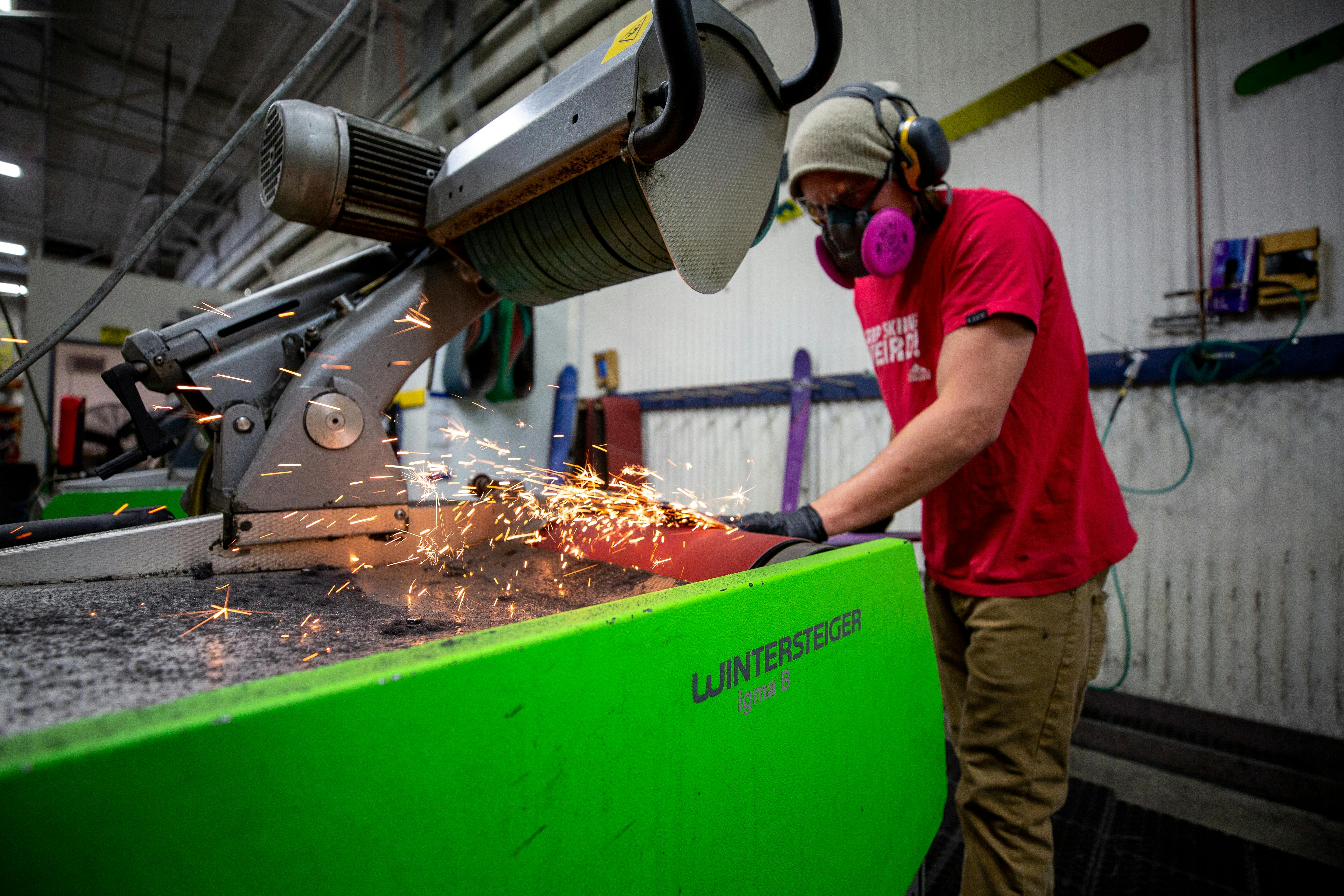 Sparks flying from a DPS ski getting shaped in the factory