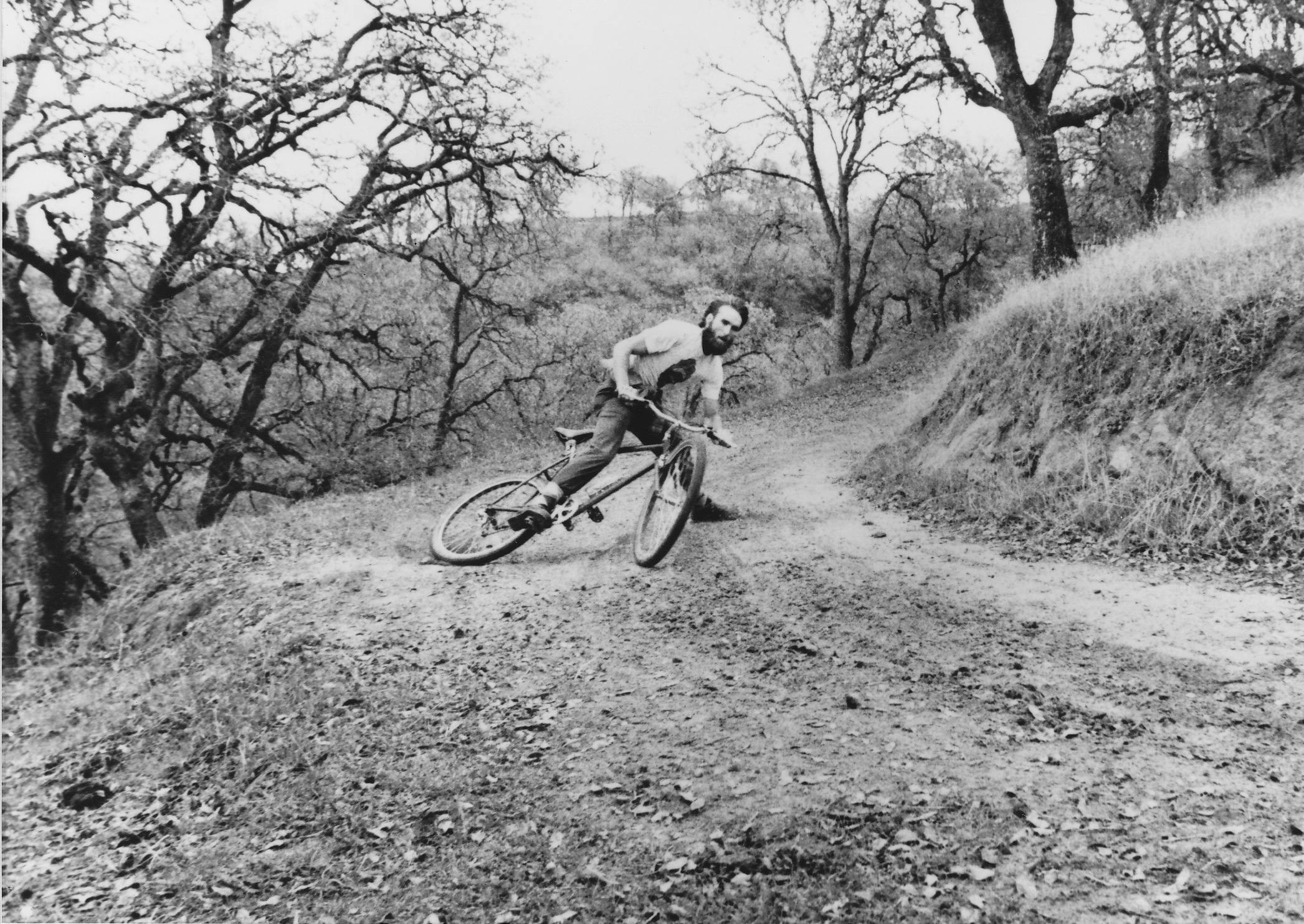 A black and white photo of Ibis Cycles Founder Scot Nicol on his Ibis #7 mountain bike on Mt. Diabo, CA in 1982.