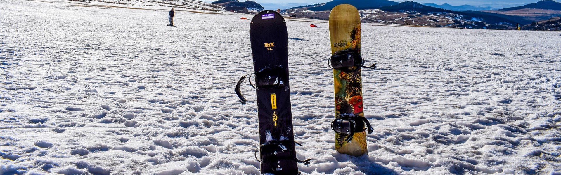 Two snowboards sticking up in the snow. 