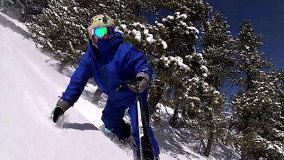 A selfie of a snowboarder turning on a snowy run. 