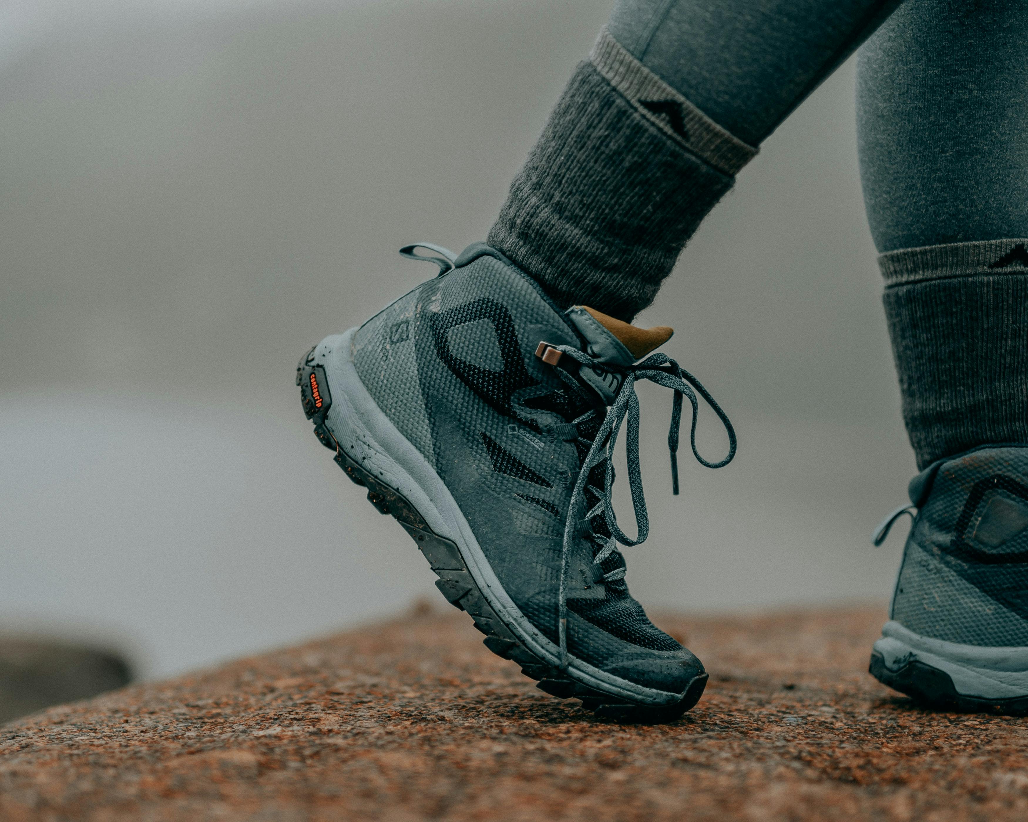 A hiking shoe and socks as someone walks along a trail. 