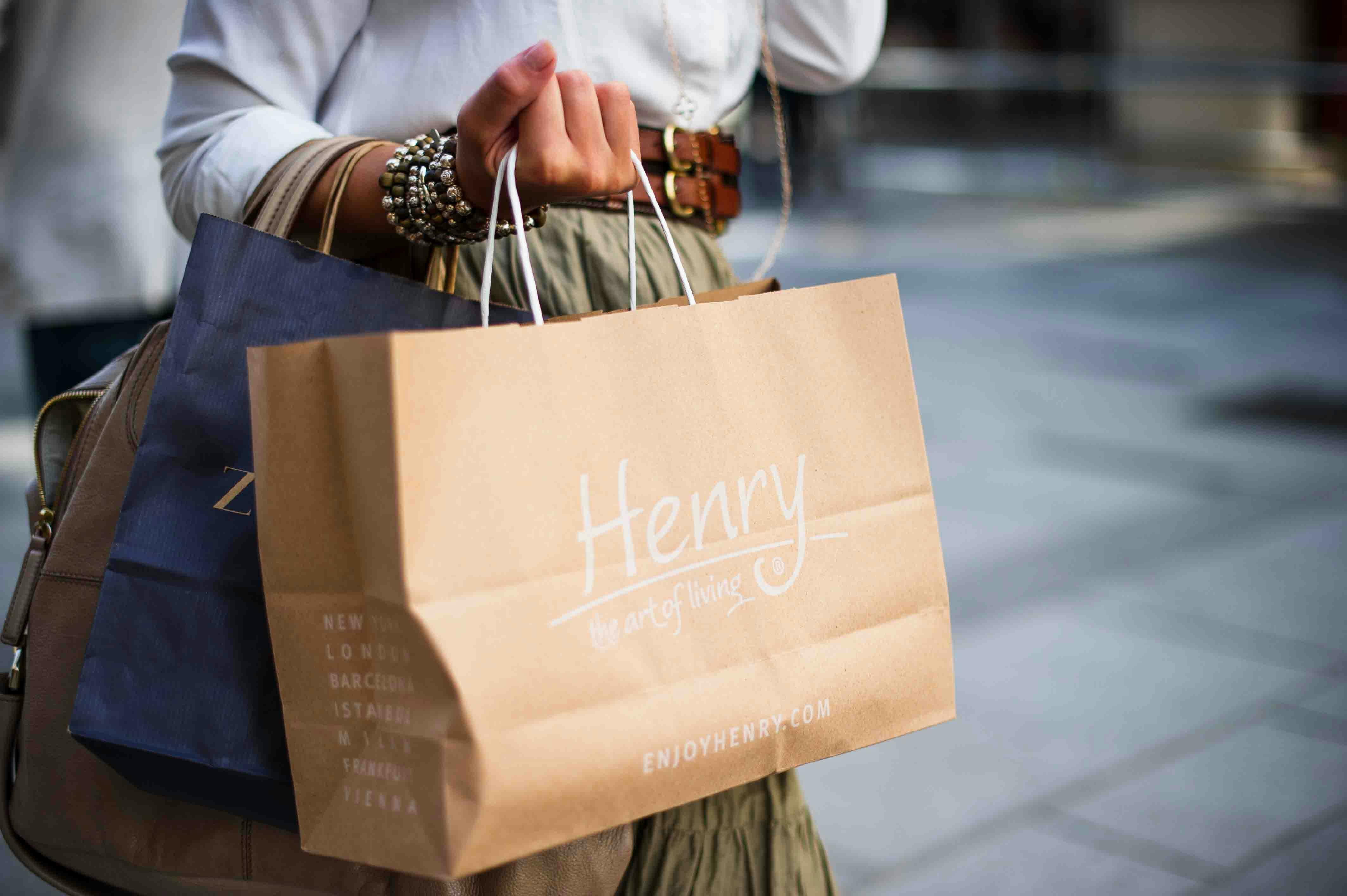A woman is holding two shopping bags.