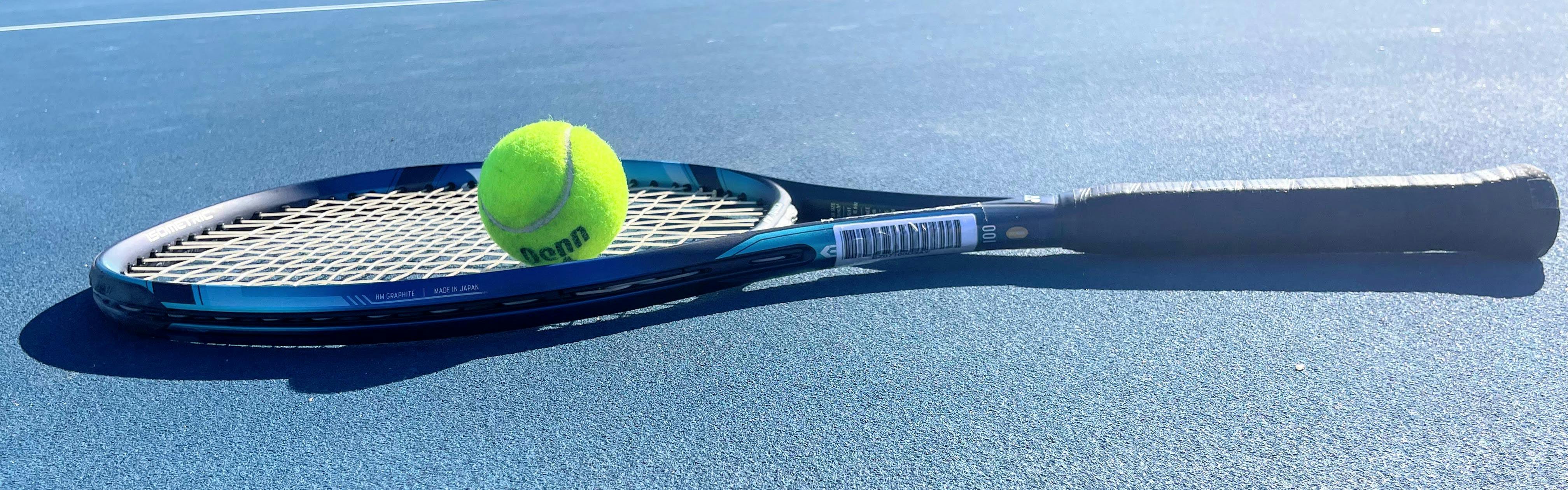 The Yonex EZone 100 Racquet with a tennis ball on it. 