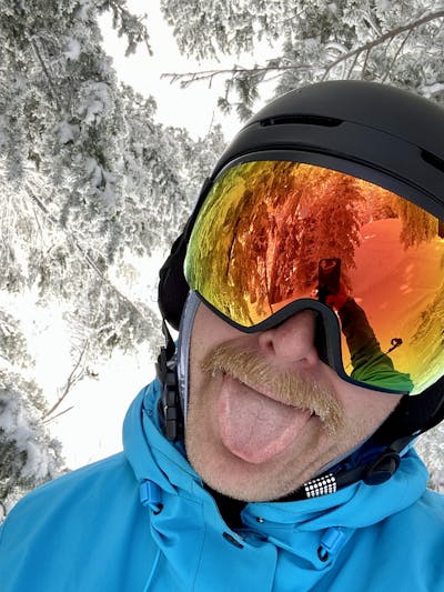 A skier wearing a helmet and the POC Fovea Clarity Goggles.