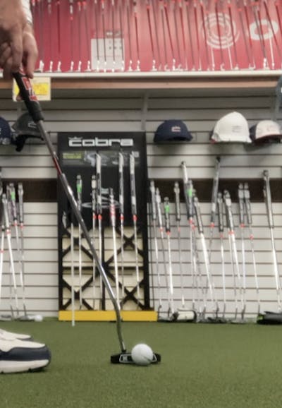 Someone using the Odyssey DFX Seven Putter in a golf store. 