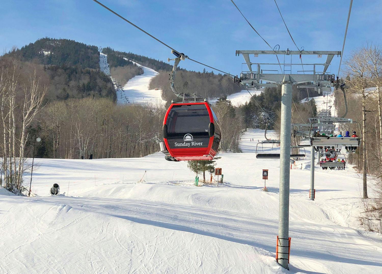 A gondola on a ski resort that reads "Sunday River".