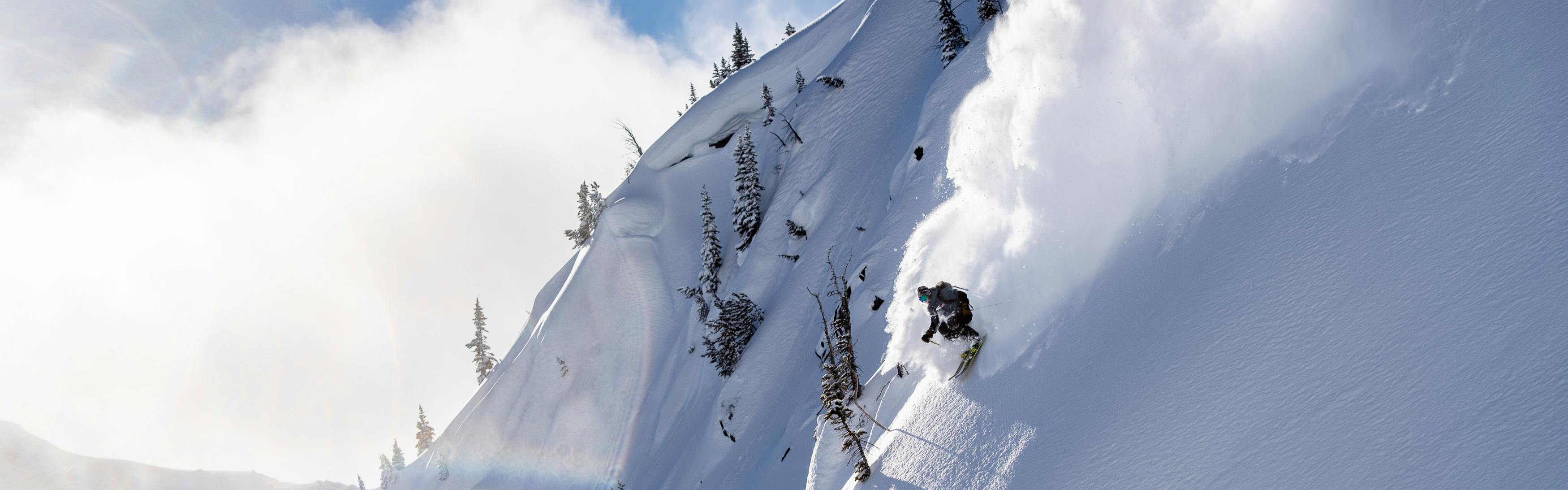 Parker White shoots down a mountain, sending a trail of powder off behind him.
