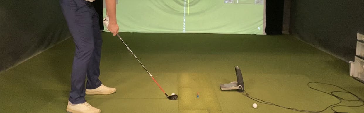 A man swinging the Callaway Apex 2021 Hybrid in a golf simulator.