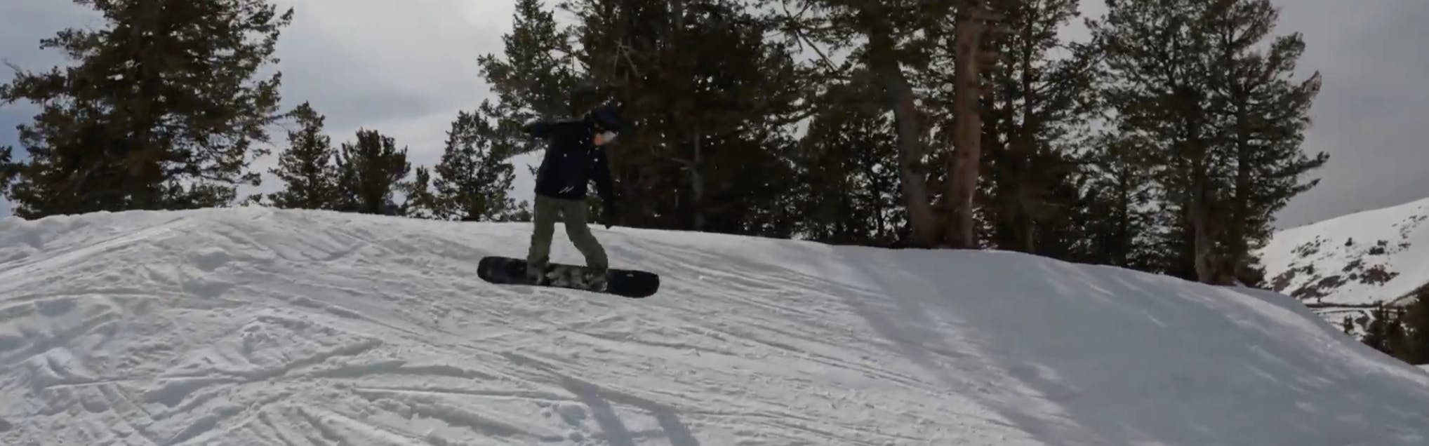 Snowboard Expert Everett Pelkey jumping with the 2023 Arbor Bryan Iguchi Pro snowboard