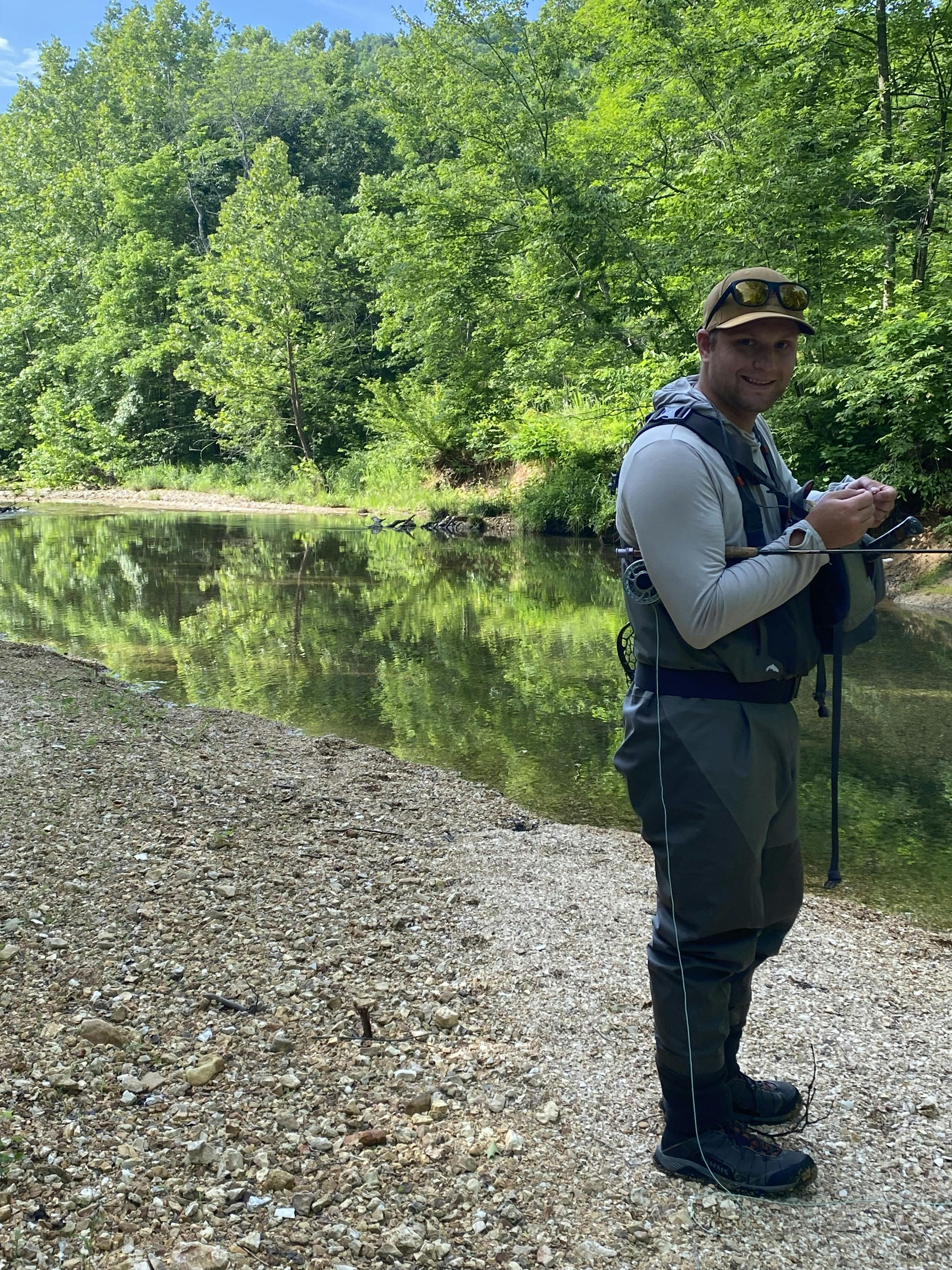 A man standing near a river with the Simms Men's G3 Guide Stockingfoot Waders on. 