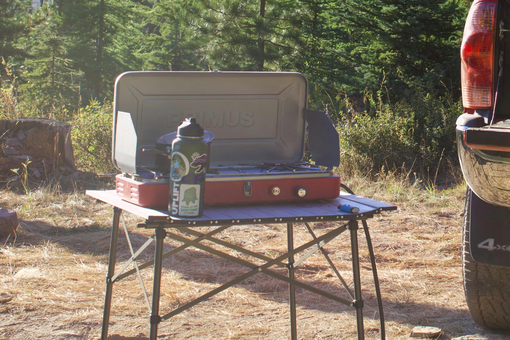 A stove sits on a camp table. 