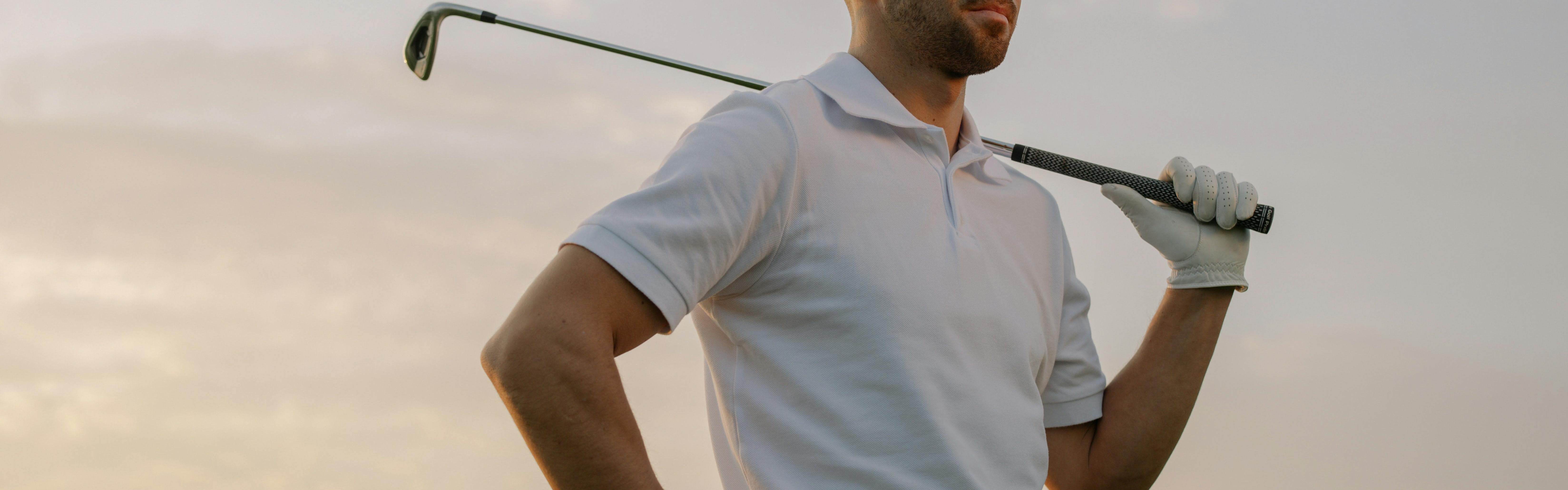 Man wearing a golf shirt and holding a golf club.