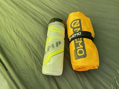 The Nemo Tensor packed in its stuff sack next to a water bottle.