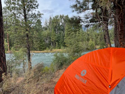 The Marmot - Tungsten 3P Tent - Blaze Steel with a river in the background. 