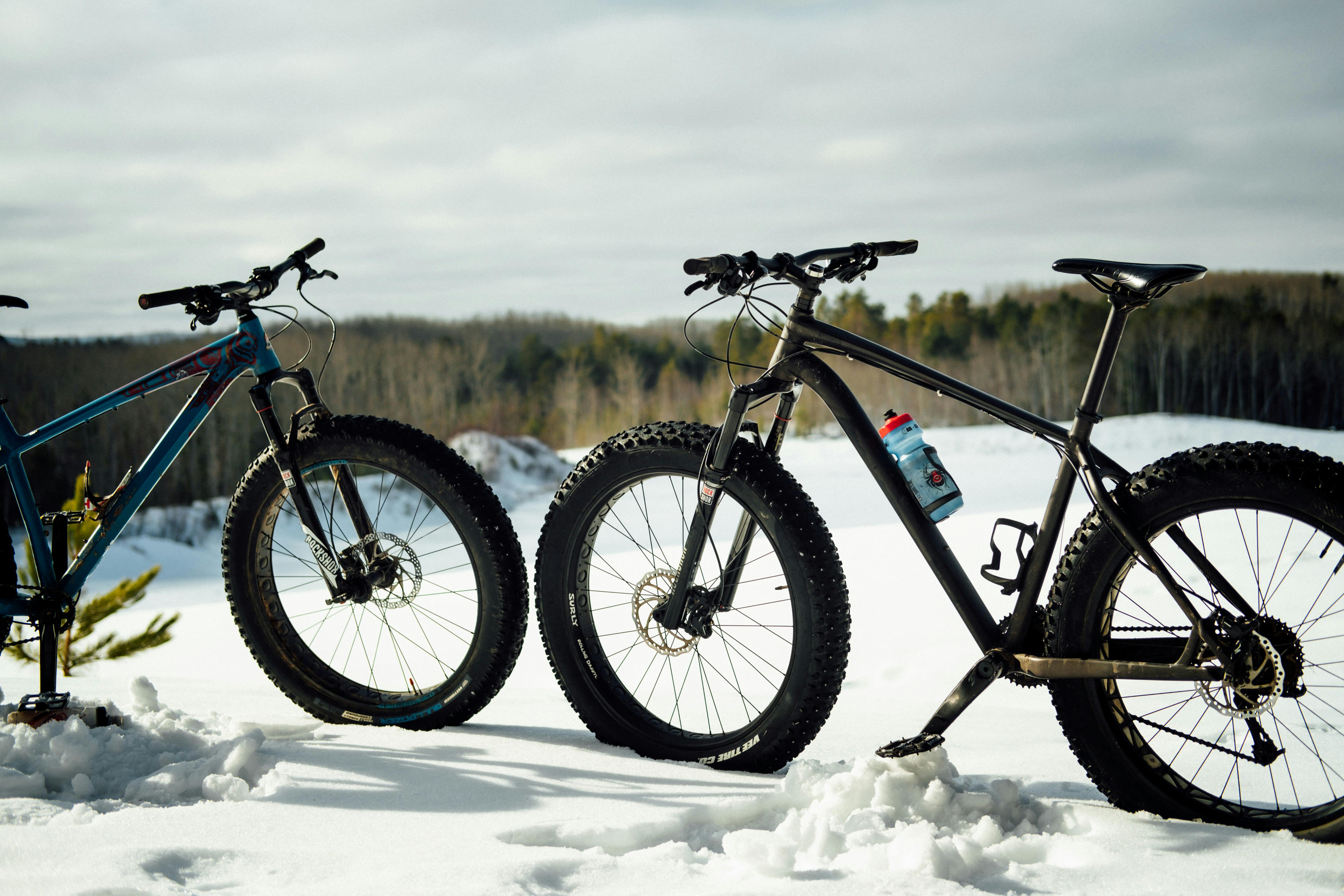 Two fat bikes standing in the snow.
