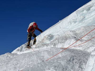 An ice climber wearing the Rab Microlight Men's Jacket. 