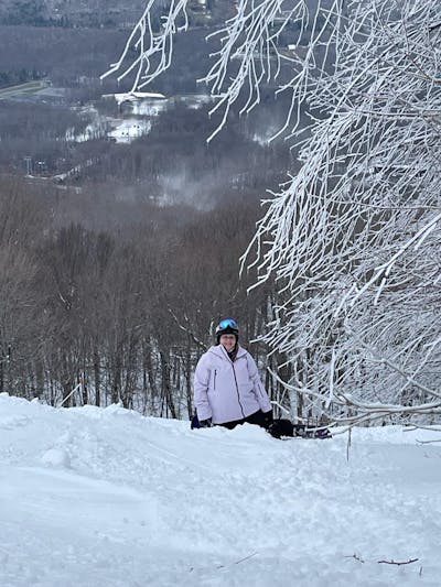 A snowboarder sitting in snow wearing the The North Face Women's Ceptor Shell Jacket.