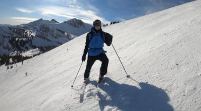 A skier stands on a run at a ski resort.